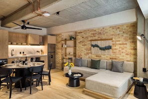 A modern kitchen with a dining area, a sofa, and a coffee table.