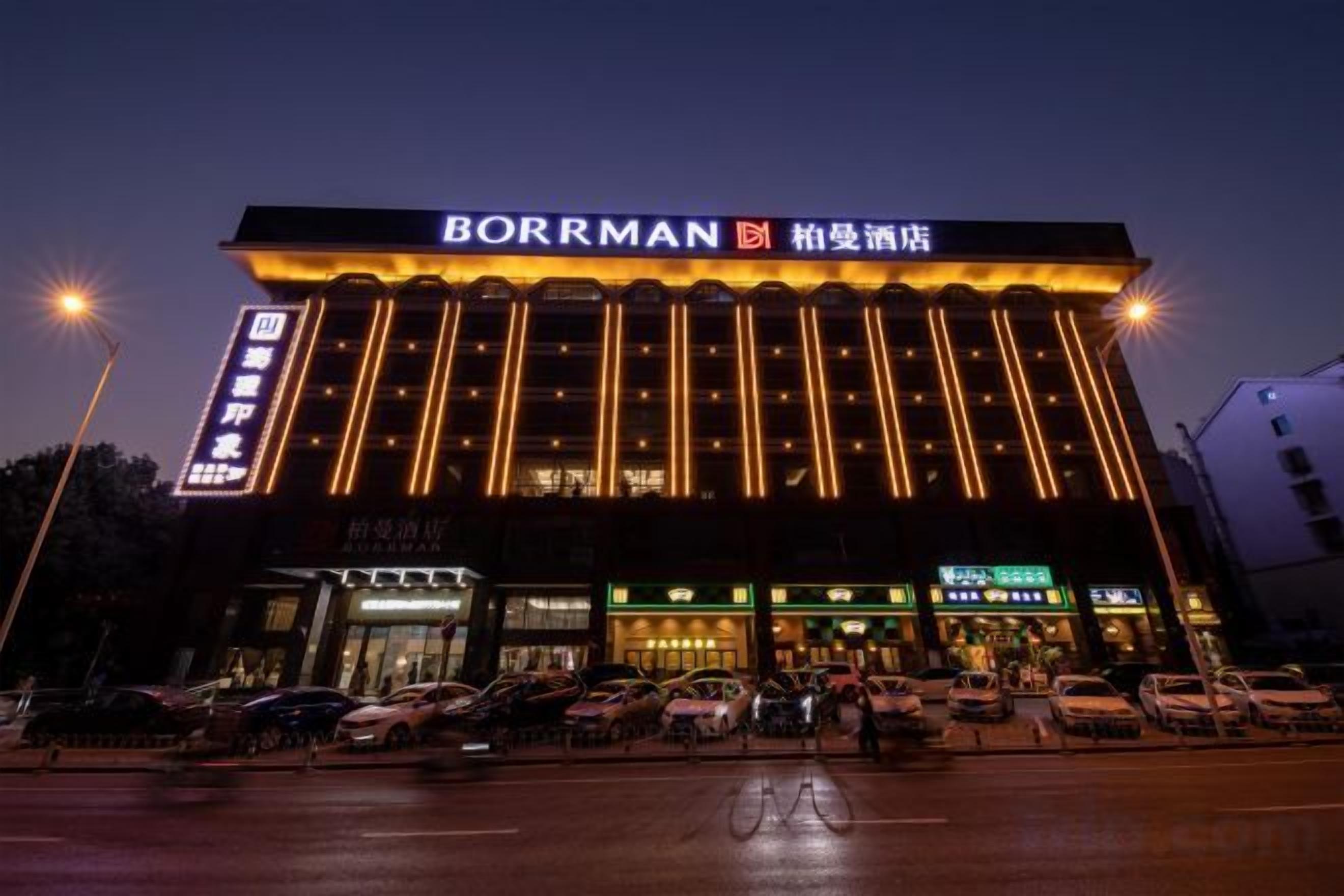 A hotel with a prominent sign, multiple floors, and a parking area in front.