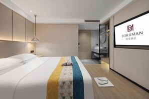 A modern hotel room with a neatly made bed, a bedside table, and a large mirror. - Borrman Hotel (Changsha Lugu Park Jiantang Subway Station) (Changsha)