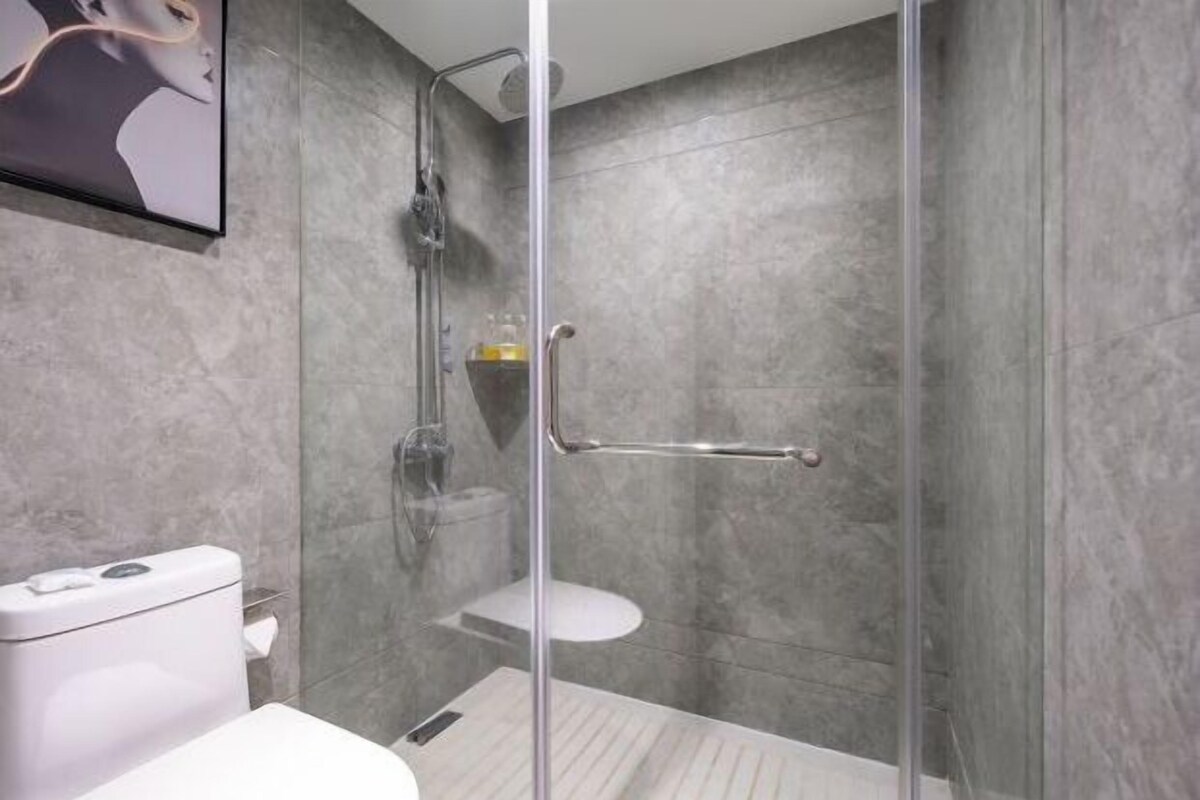 Un baño moderno con ducha acristalada, inodoro y lavamanos.
