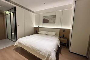 A hotel room with a bed, bedside table, and a painting on the wall. - Home Inn Ruibai Cloud Hotel (Longyan Railway Station Zhongshan Road Branch) (Longyan)