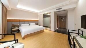 Una habitación de hotel moderna con una cama grande, mesitas de noche, un escritorio y una silla.