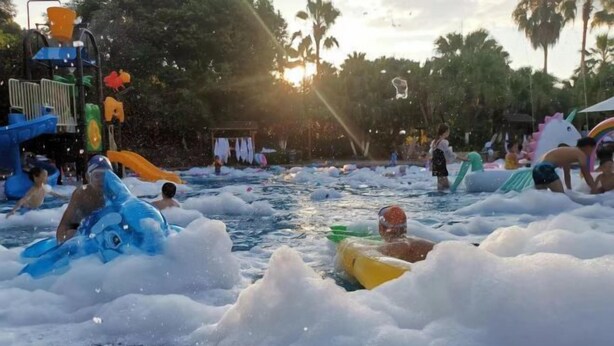Un parque acuático con balsas inflables y un tobogán de agua.