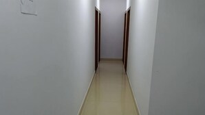 A narrow, well-lit hallway with a shiny floor, leading to a door at the end. - Huangshan Qiyunshan Yuehua Building Accommodation (Xiuning)