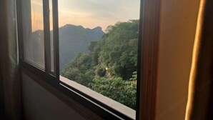 Une fenêtre donnant sur un paysage montagneux.