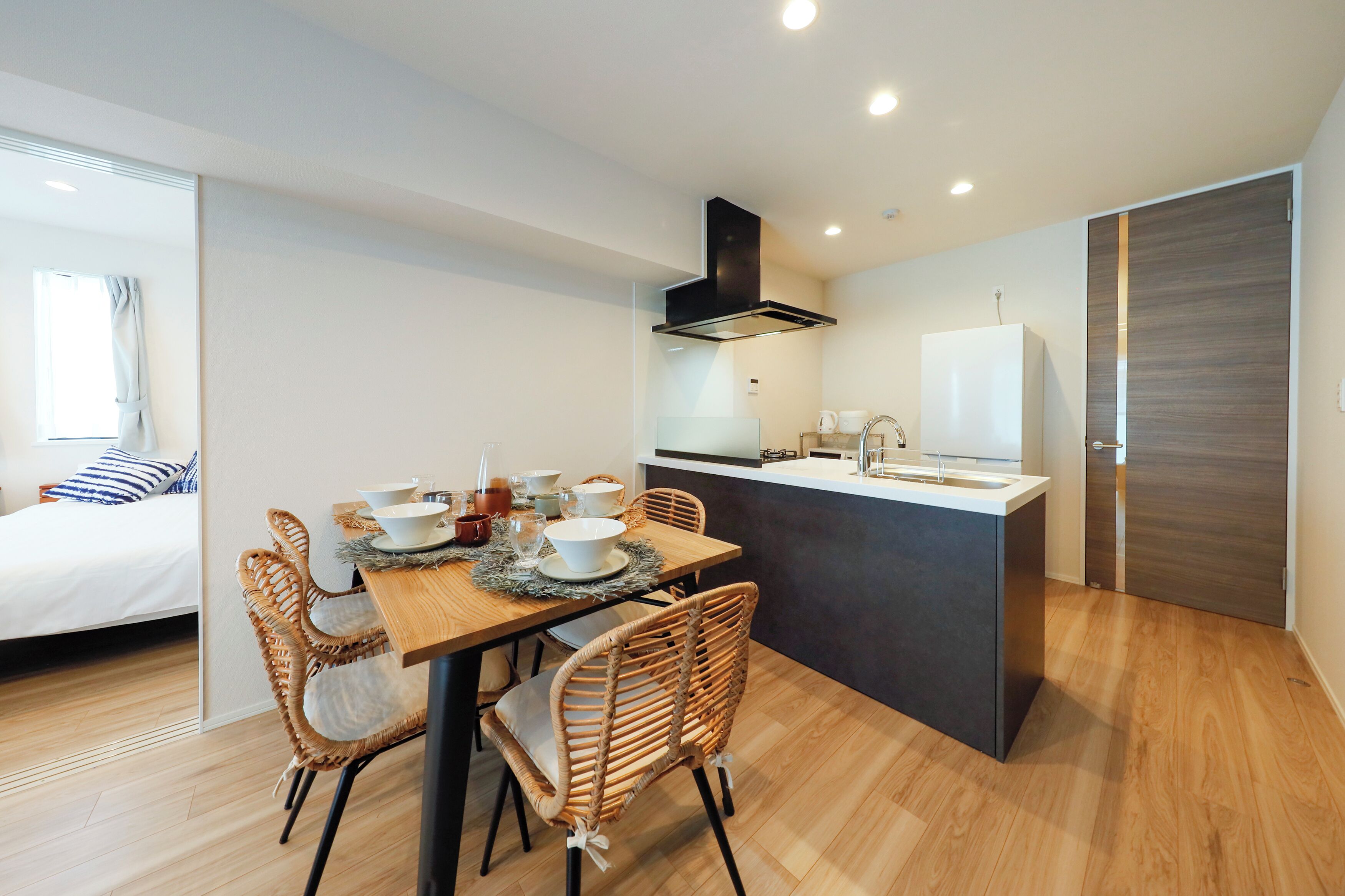 Cocina compacta con comedor, cama y un ventanal grande.