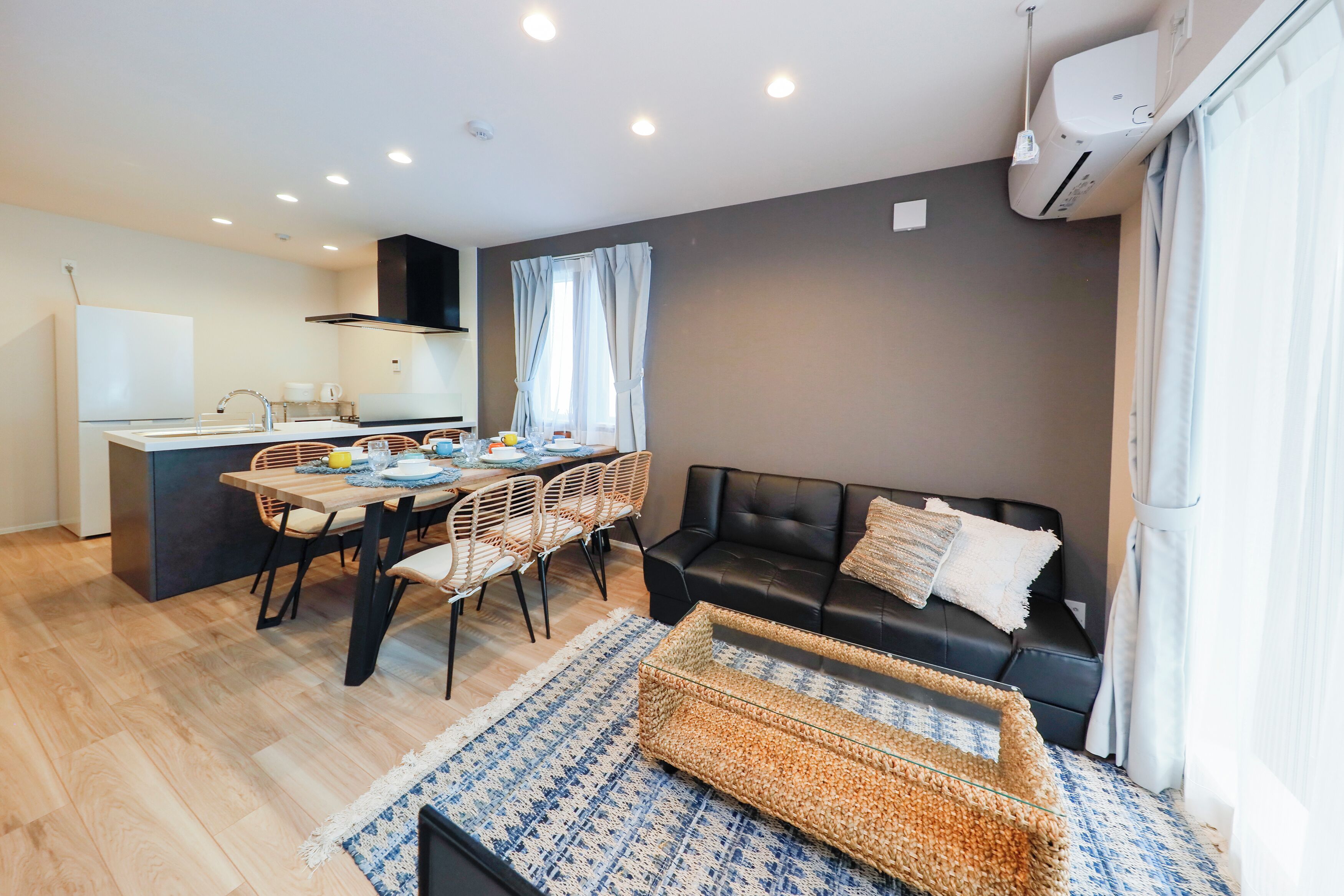 A compact living space with a kitchenette, dining area, and a sofa.