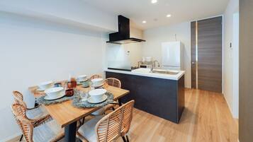 Una cocina moderna con comedor, suelo de madera e isla integrada con pileta.