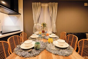 A dining table set with plates, cups, and a vase of flowers. - Pacific Coast Enoshima by Tranova (Fujisawa)