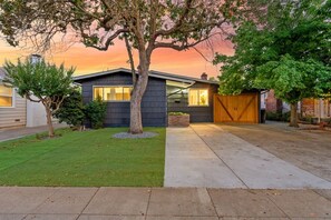 A modern single-story house with a well-maintained lawn, a driveway, and a garage. - Main Street Retreat in Roseville (Roseville)