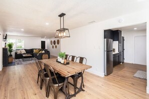 A modern apartment with a dining area, kitchen, and living room.