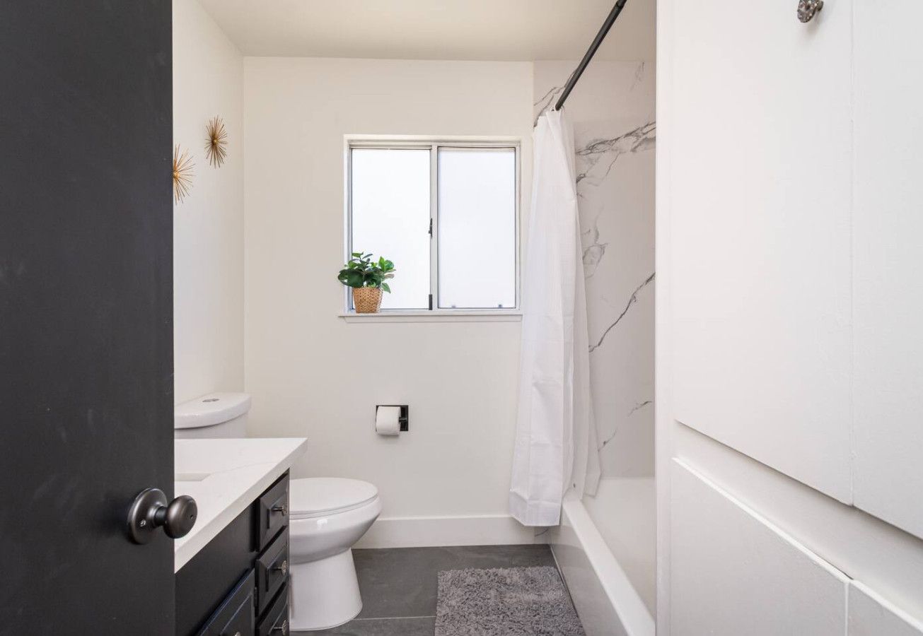 Une petite salle de bain comprenant des toilettes, un lavabo et une fenêtre.