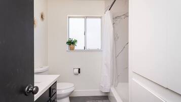 Une petite salle de bain comprenant des toilettes, un lavabo et une fenêtre.