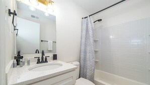 A modern bathroom with a white sink, mirror, and toilet. - Sojourn's Harborage - Dock Suite (Norfolk)
