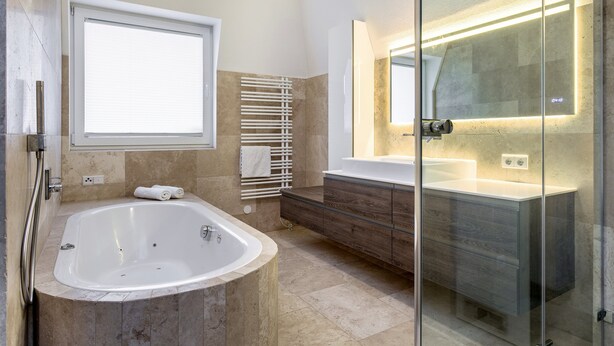 Une salle de bain moderne avec une baignoire îlot, une douche à parois de verre et un meuble-lavabo avec un miroir.