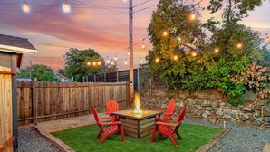 A backyard with a fire pit, outdoor seating, and string lights. - Studio on Main Street  (Roseville)