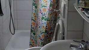 Un baño con ducha, inodoro y lavamanos.