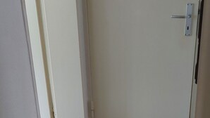 Un pasillo con piso de madera y una puerta cerrada.