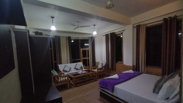 Ein Hotelzimmer mit Bett, Schreibtisch, Stuhl und Fernseher.