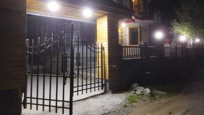 Ein verschlossener Eingang zu einem Gebäude bei Nacht, mit einer Treppe, die zu einer zweiten Etage führt.