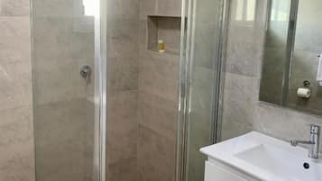 Appartement Deluxe, 2 grands lits, balcon | Salle de bain | Douche, articles de toilette (gratuits), serviettes fournies, savon