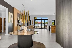 A modern interior with a central glass table, a large window with a view, and contemporary decor. - Star Villa | Opulent Waterfront Property (North Miami Beach)