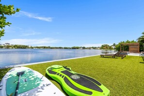 Ein Poolbereich mit einem grünen Stand-Up-Paddleboard, einer Liege und einer kleinen Holzkonstruktion.