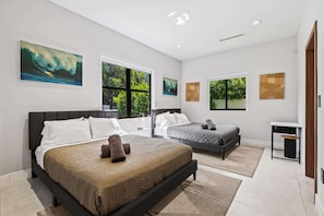 A modern bedroom with two beds, large windows, and artwork on the walls. - Star Villa | Opulent Waterfront Property (North Miami Beach)