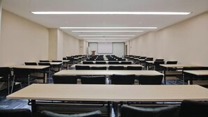 A conference room with rows of tables and chairs, a projector screen, and a podium. - HanTing Hotel (Xi'an Bianjiacun Subway Station) (Xi'an)