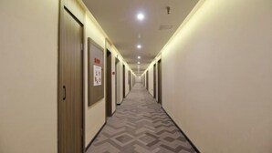 A long, narrow hotel corridor with doors on both sides, a patterned carpet, and recessed lighting. - HanTing Hotel (Xi'an Bianjiacun Subway Station) (Xi'an)