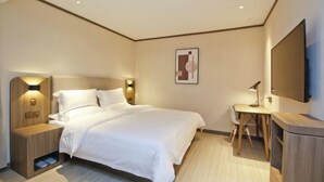 A modern hotel room with a neatly made bed, a desk with a chair, a flat-screen TV, and a wall-mounted artwork. - HanTing Hotel (Xi'an Bianjiacun Subway Station) (Xi'an)