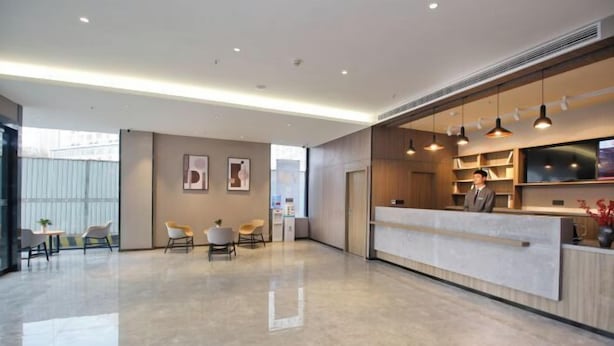 A modern hotel lobby with a reception desk, seating area, and a large window. - HanTing Hotel (Xi'an Bianjiacun Subway Station) (Xi'an)