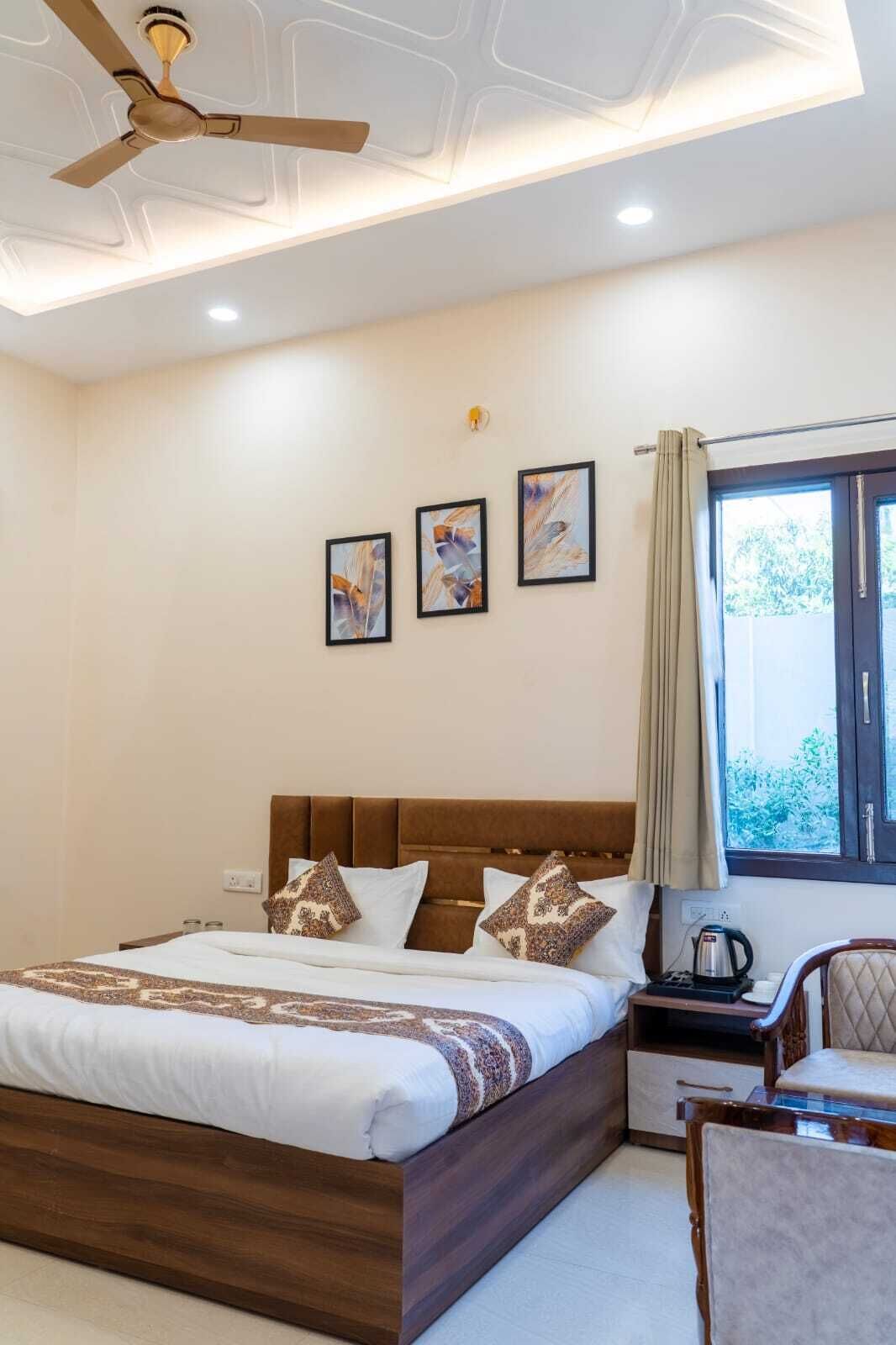 A bedroom with a bed, a nightstand, a chair, a window, and ceiling fans.