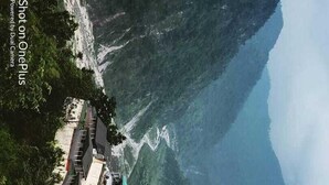 Un bâtiment traditionnel à plusieurs étages, situé sur une pente rocheuse abrupte.