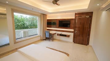 Ein Schlafzimmer mit Bett, Schreibtisch, Stuhl, Fernseher und Kleiderschrank.