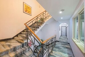 A staircase with a handrail and a carpeted floor, leading to a door at the top. - Siji Xiaozhu Hotel (Danzhai)