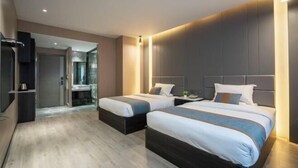 A modern hotel room with two beds, a built-in desk, and a separate bathroom. - Siji Xiaozhu Hotel (Danzhai)