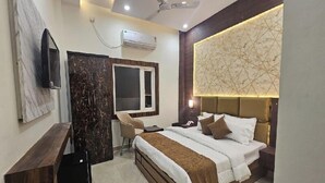 Una camera d'albergo moderna con un letto, una scrivania, una sedia e una televisione.
