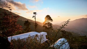 A tented area with a view of a valley and mountains in the background. - Luxcamp Dieng by Horison (Kejajar)