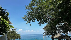 A coastal view with a wooden deck, a gazebo, and a clear blue sky. - shari-la Perhentian Island Resort (Pulau Perhentian Kecil)