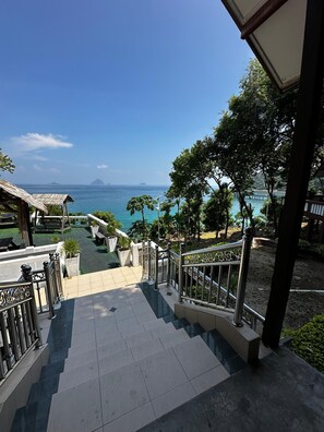 Una escalera lleva a una terraza con vistas al mar y a islas lejanas.