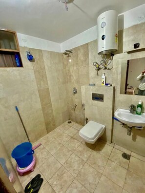 A bathroom with a shower, toilet, sink, and a water heater. - Hotel & BNB Solanki Residency Jaipur (Jaipur)