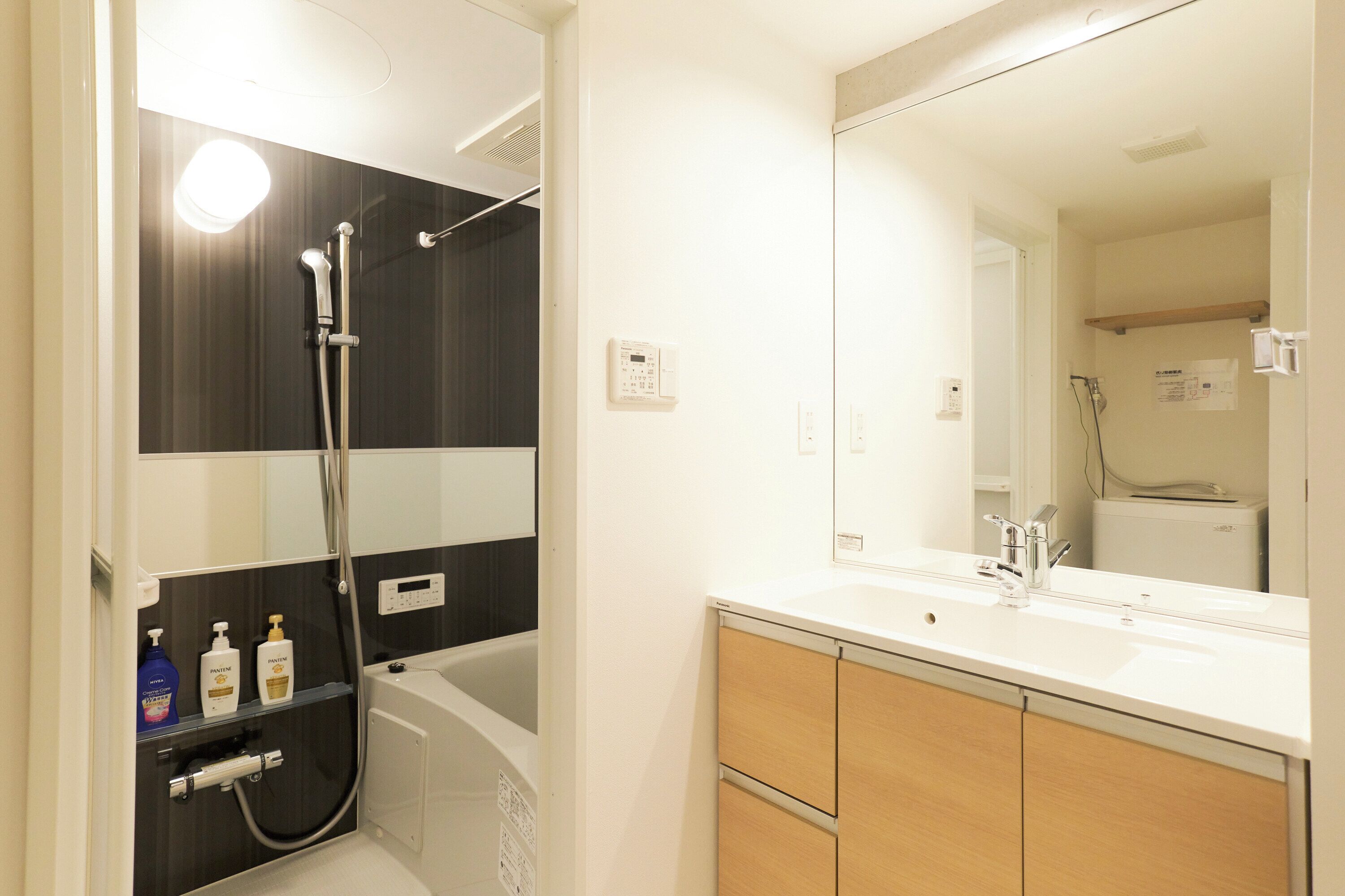 Combined shower/bathtub, hair dryer, slippers, towels