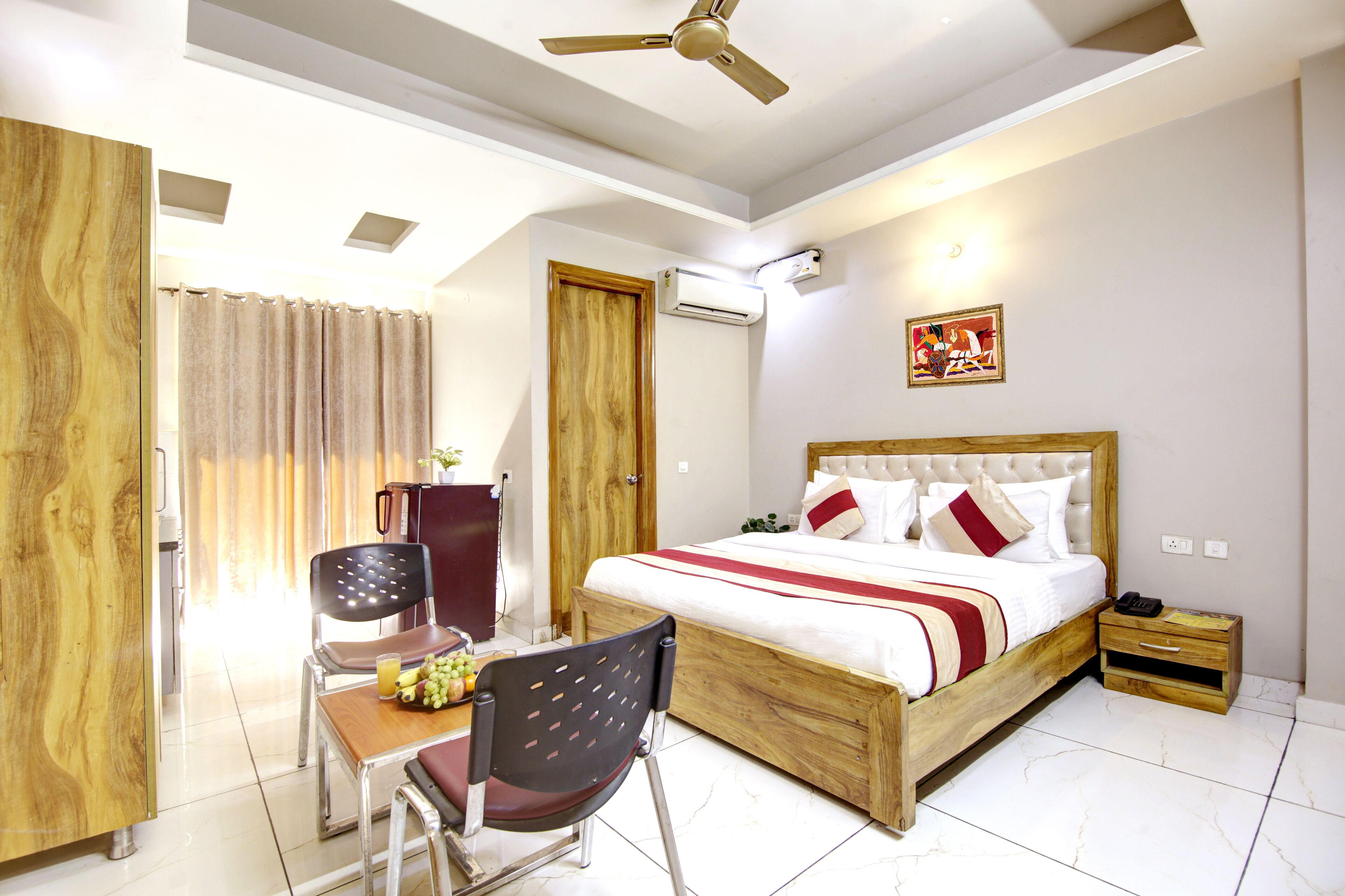 A bedroom with a wooden bed, a desk with a chair, a ceiling fan, and a nightstand.