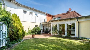 A house with a garden, a patio, and a satellite dish. - Holiday Home 'Ferienhaus Sommerrose' with Private Terrace, Private Garden and Wi-Fi (Oberuckersee)