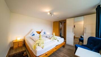 Une chambre à coucher avec un lit en bois, des tables de chevet, une chaise et une armoire.