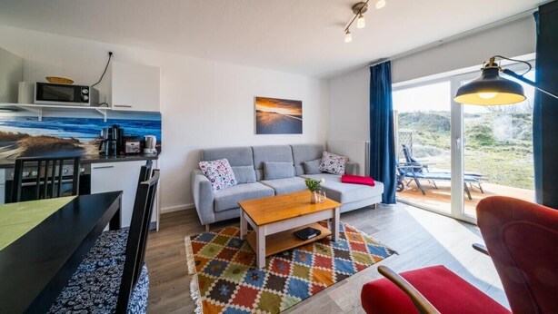 Una sala moderna con sofá, mesa de centro y vistas al exterior.