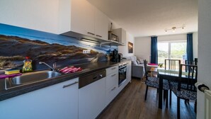 Una cocina moderna con una isla grande, electrodomésticos integrados y un comedor con vistas.