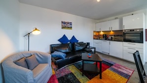 Un salon moderne avec un canapé, une table basse et un tapis aux couleurs vives.