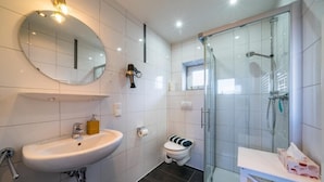 Une salle de bain moderne avec un lavabo, des toilettes et une douche à parois de verre.